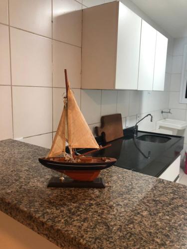 a small sail boat on a counter in a kitchen at Apartamento Vista total do Mar uma cobertura a 400m do Beach Park no Porto das Dunas Aquiraz Condomínio Terramaris Piscina ampla Parque infantil Sauna Estacionamento privado in Aquiraz