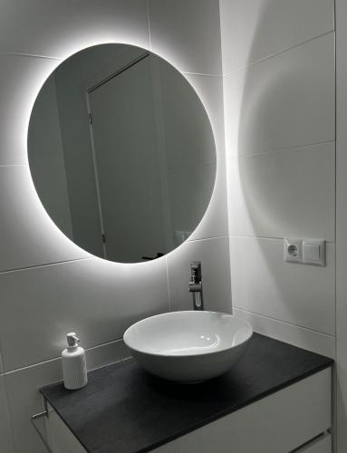 a bathroom with a white sink and a mirror at Apartamento A Cachola in Cangas de Morrazo
