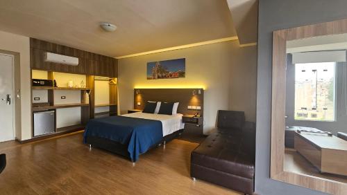 a hotel room with a bed and a couch at Valle Sur Hotel Moquegua in Moquegua