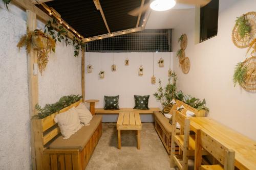 a room with benches and potted plants on the wall at Pallet Homes - Petalsville in Iloilo City