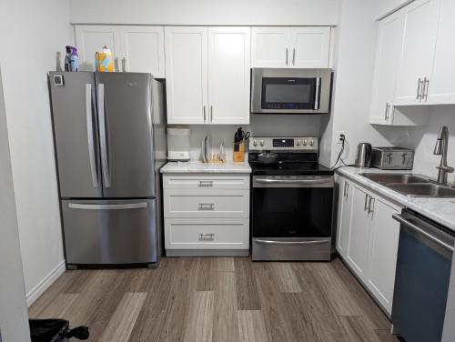 kuchnia z białymi szafkami i urządzeniami ze stali nierdzewnej w obiekcie Home of Pleasantness w mieście Hamilton