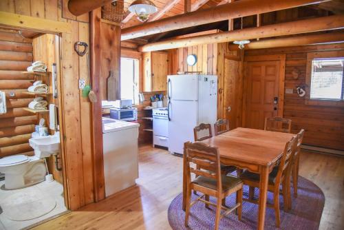 een keuken met een houten tafel en een witte koelkast bij Bear Bait Cabin In Upper Valley With High Speed Wifi in Red River