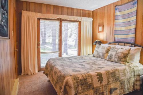 een slaapkamer met een bed en een groot raam bij Bear Bait Cabin In Upper Valley With High Speed Wifi in Red River