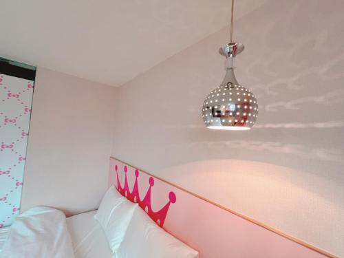 a bedroom with a pink headboard and a pendant light at Fuyale Hotel in Taipei