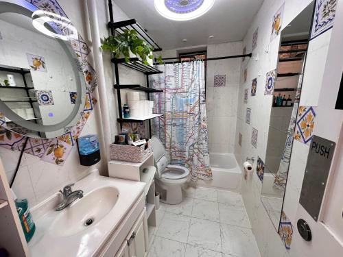 een badkamer met een wastafel, een toilet en een spiegel bij Lemon private room with shared bathroom in New York