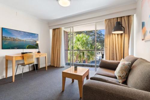 a living room with a couch and a desk at Magical Manly in Sydney