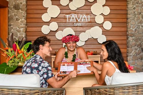 a group of three people sitting at a table at Le Bora Bora by Pearl Resorts in Bora Bora