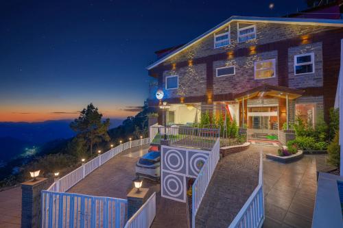 a large house with a balcony at night at Hotel Wood Stock Luxury - A Boutique Property - Penthouse - Open Air Restaurant & Terrace in Kasauli
