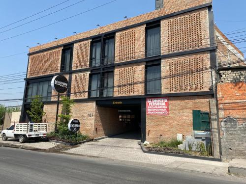 a brick building with a garage on a street at Motel London in Guadalajara