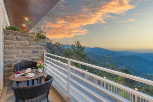 a balcony with a table and chairs with a view of mountains at Hotel Wood Stock Luxury - A Boutique Property - Penthouse - Open Air Restaurant & Terrace in Kasauli