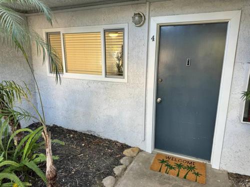 a front door of a house with a window and a cat sitting in the window at Carpinteria Beach Studio Condo in Carpinteria