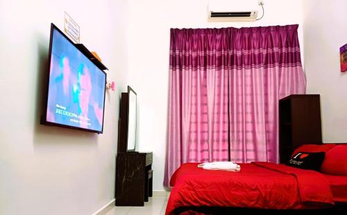 a bedroom with a red bed and a flat screen tv at Kuantan Homestay Best Facility Wifi BBQ Viu in Kuantan