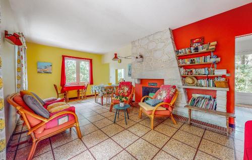 a living room with orange and yellow walls at Nice Home In Saint-Georges-De-Didon in Saint-Georges-de-Didonne