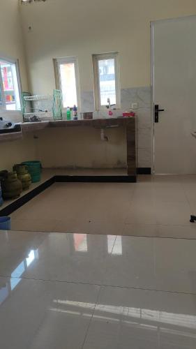 a large room with a white floor and windows at Villa kota bunga 3 BR Kolam renang pribadi in Cipanas