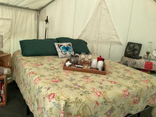 ein Bett in einem Zelt mit einem Tablett darauf in der Unterkunft Sticks creekside Living in Turtletown