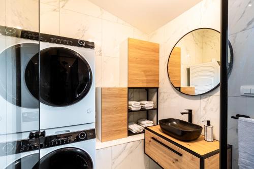 a bathroom with two washing machines and a mirror at Jackal Holiday House with a heated pool and a jacuzzi in Lovreć