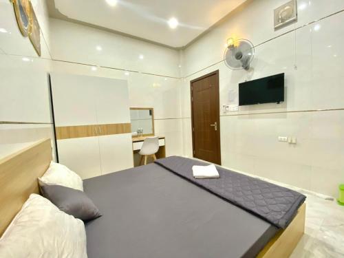 1 dormitorio con 1 cama y TV de pantalla plana en Motel Hòa Hiệp, en Binh Chau
