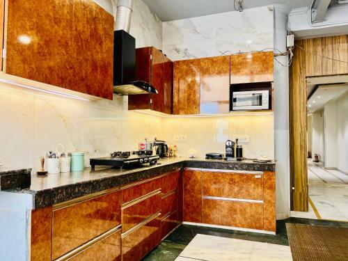 a kitchen with wooden cabinets and a counter top at Divine Inn Hotel Near Rajouri Garden Main Market in New Delhi
