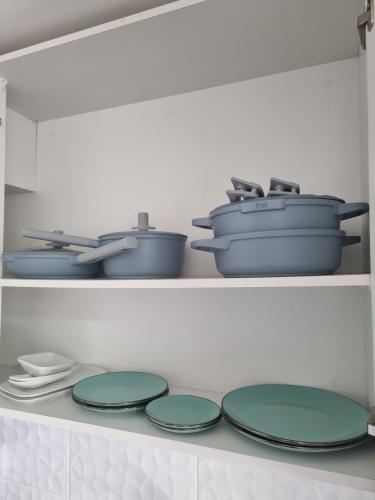 a row of plates and pots and pans on a shelf at A pasos de la UDEC y centro in Concepción