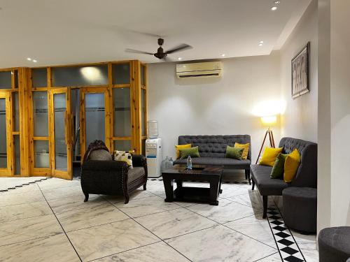 a living room with two couches and a table at Divine Inn Hotel Near Rajouri Garden Main Market in New Delhi