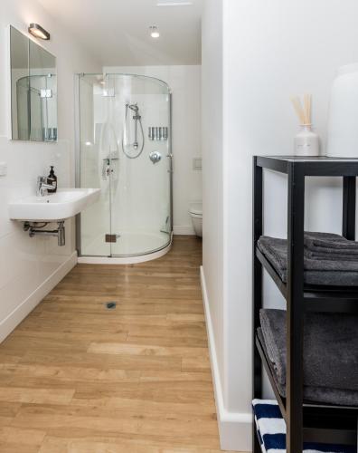 a bathroom with a shower and a sink at Seaside at Eleven Mt Maunganui in Mount Maunganui