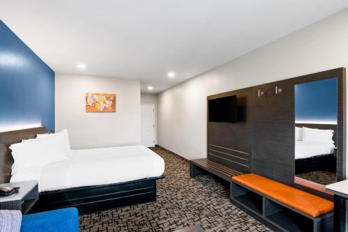 a hotel room with a bed and a flat screen tv at Econo Lodge Bethel - Danbury in Bethel