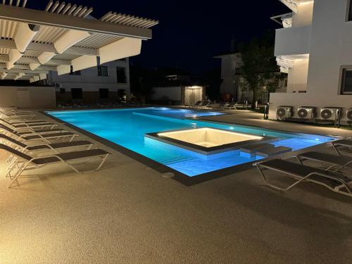 a swimming pool at night with chairs around it at Studio Nikiti Beach in Nikiti