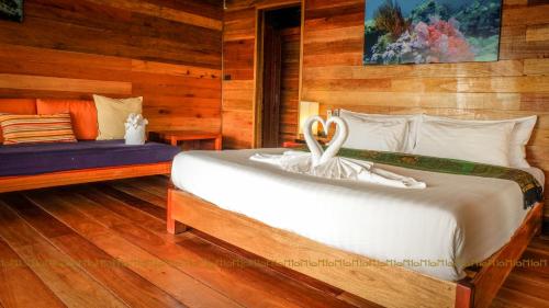 a bedroom with a large bed with a wooden wall at Ten Moons Lipe Resort in Ko Lipe