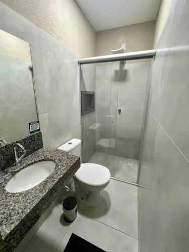 a bathroom with a toilet and a glass shower at Morada do Lago in Palmas