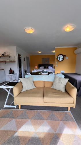 a living room with a couch and a kitchen at Mohua Park - Catlins Eco Accommodation in Owaka
