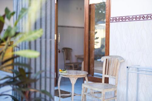 a table and chair on a porch with a mirror at Sanata Yoga Guesthouse in Canggu
