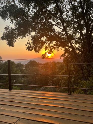 a sunset from a deck with a tree at Casa Alrededor de un Pino in Mazamitla