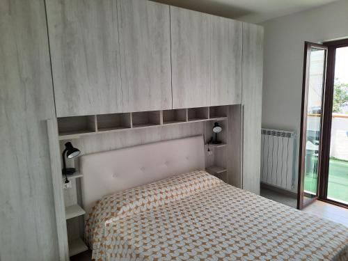 a bedroom with a bed with a wooden headboard at Appartamenti Miramare in Marina di Camerota