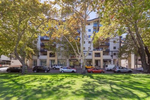 a park with cars parked in front of a building at 2X1 Comfy Apartment in Perth CBD in Perth