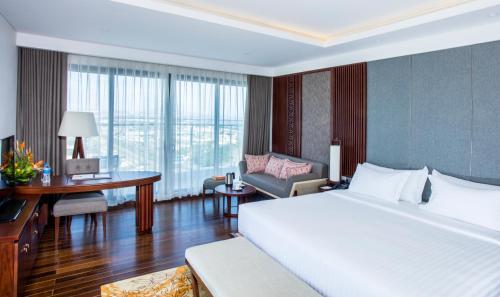 a hotel room with a large bed and a desk and a desk at Duyen Ha Resort Cam Ranh in Cam Ranh