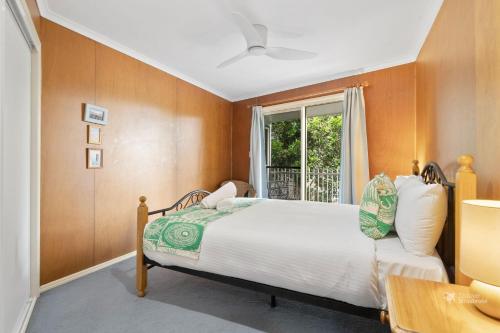 a bedroom with a bed and a window at A Turtle House by Discover Stradbroke in Point Lookout