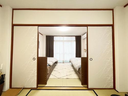 a room with a door leading to a bedroom at Feliz Kumamoto in Kumamoto