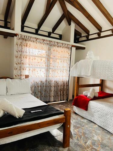 1 Schlafzimmer mit 2 Etagenbetten und einem Fenster in der Unterkunft Hostal El Palacio Del Descanso in Villa de Leyva