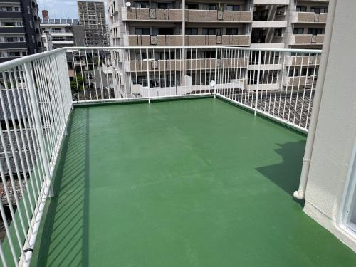 a balcony with a green floor on a building at Feliz Kumamoto in Kumamoto