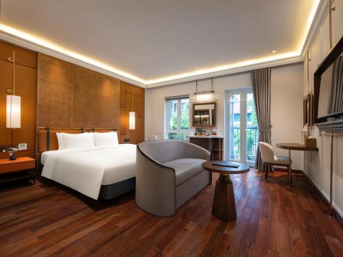 a hotel room with a bed and a chair at Minerva Premium Hotel in Hanoi