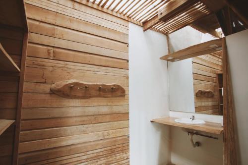 Łazienka z drewnianą ścianą i umywalką w obiekcie La Fauna Hotel w mieście Puerto Maldonado