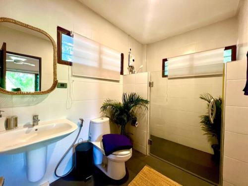 Un baño con lavabo, inodoro y espejo. en Natural Villas Na Jomtien Pattaya Private Pool, en Bang Sare