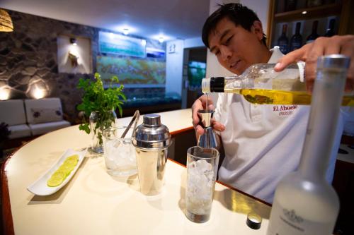 a man pouring a bottle of wine into a glass at Hotel El Abuelo in Carhuaz