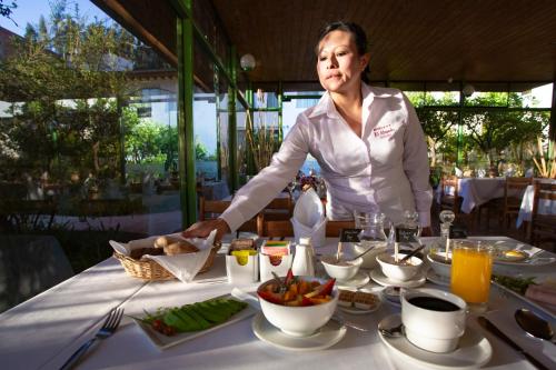 a woman standing in front of a table with food at Hotel El Abuelo in Carhuaz
