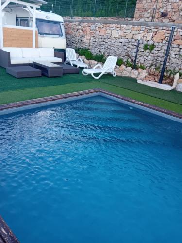 una piscina in un cortile con sedie e camper di LE TERRAZZE SUL GARDA RELAIS a Biaza