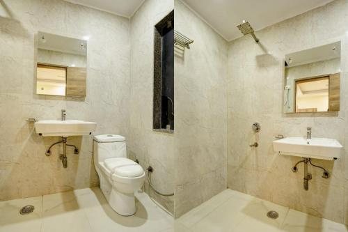 La salle de bains est pourvue de toilettes et de 2 lavabos. dans l'établissement Hotel New City Lite, à New Delhi