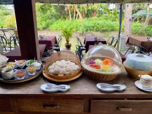 a table with bowls and plates of food on it at House Of Passion Amphawa in Amphawa