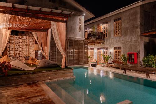 a swimming pool in a room with a house at House Of Passion Amphawa in Amphawa