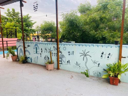 a wall with a mural of plants on it at NeemTree Homestay NewHampi in New Hampi