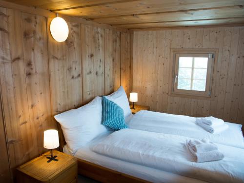 Alpine Hut Acla Sissi Lenzerheide for 10 people tesisinde bir odada yatak veya yataklar